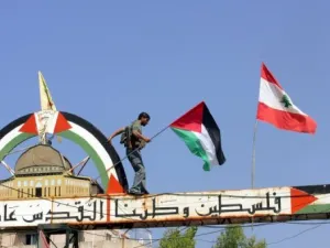 فلسطيني يعتلي لافتة في مخيم عين الحلوة