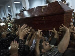 Egyptian Copts carry coffins down the aisle of the Virgin Mary Coptic Christian church in Cairo's working class neighbourhood of Al Warrak, on October 21, 2013. (AFP)
