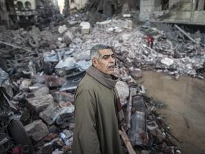 An Egyptian man stands amidst debris car at the site of a powerful car bomb explosion in the Egyptian city of Mansoura, North of Cairo, on December 24, 2013.  (AFP)