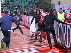 Ahli players being rushed to safety.