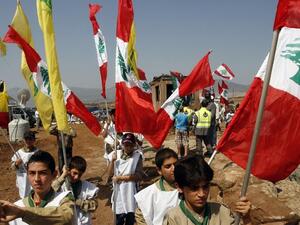 Young boys of Hezbollah's al-Mehdi scouts wave Lebanese and Hezbollah flags during a parade in the southern area of Wazzani river on the Lebanese-Israeli borders, on August 2, 2013. (AFP)