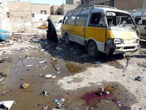 An Iraqi woman walks across the debris following an explosion at a bus center on October 27, 2013, in the the Mashtal district of the capital Baghdad, as eight car bombs exploded in Shiite-majority areas of Baghdad province. (AFP)