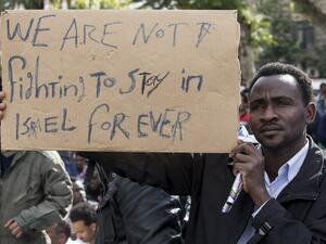 A protestor holds up a sign in English as thousands of African asylum seekers who entered Israel illegally via Egypt staged a protest in Tel Aviv on January 7, 2014, slamming the Jewish state's long-term detention of African migrants. The protest continued to Jerusalem on Wednesday. (AFP)