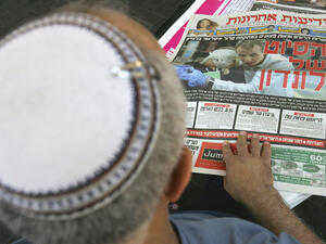 A Jewish faithful reads his daily paper. Shown strictly for illustrative purposes.