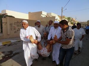Iraqis carry a wounded man at the scene of a car bomb attack after it exploded as worshippers left a Sunni mosque following prayers marking the start of the Eid Al Adha Muslim holiday in the northern Iraqi city of Kirkuk on October 15, 2013. (AFP)