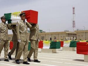 Iraqi Kurdish police officers carry a coffin draped with the Kurdish flag, on May 28, 2012 (AFP/File)