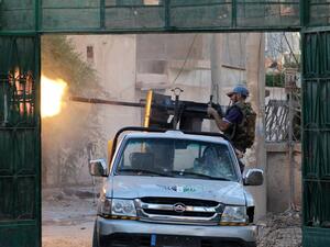 A Syrian rebel fighter fires from a truck during clashes with forces loyal to the regime in the eastern Syrian town of Deir Ezzor on August 1, 2013. (AFP)