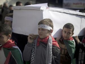 Palestinian children carry a fake coffin as they take part in a sit-in on January 4, 2014 in Gaza city in solidarity with Palestinian children at Yarmouk refugee camp in Syria. (AFP)