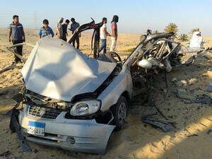 Egyptians gather near a damaged car bomb that detonated before reaching the intended target killing three passengers (AFP/STR)