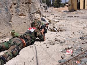 A member of the Syrian armed forces takes position during a patrol near Al Manashir roundabout in Jobar in the outskirts of Damascus on July 14, 2013. (AFP/SANA)