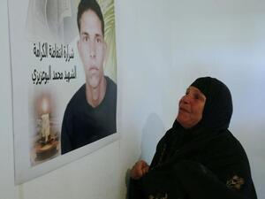 Mohamed Bouazizi's mother, Mannoubia Bouazizi, looks on to his memory. (Image courtesy of "ibtimes.com")