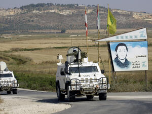 Spanish peacekeepers of the United Nations Interim Force in Lebanon (UNIFIL) patrol in their armoured vehicles near a placard of Hezbollah (AFP/MAHMOUD ZAYYAT)