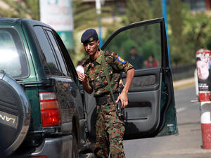 A police trooper inspects a vehicle at the entrance of the Sanaa International Airport (AFP/MOHAMMED HUWAIS)