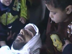 صورة من شريط على يوتيوب الجمعة 4 تشرين الثاني/نوفمبر يظهر طفلين جالسان قرب جثة قتيل ذكر ناشطون انه اسمه يحي الحمد من باب عمرو في حمص
