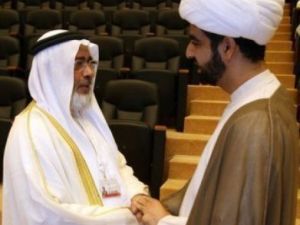 رئيس مجلس النواب البحريني خليفة الظهراني (يسار) مصافحا رجل دين شيعي في افتتاح الحوا