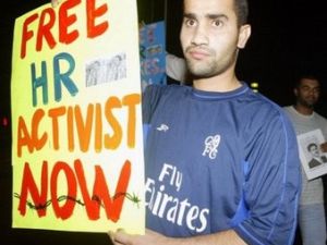 ناشط حقوقي بحريني يحمل لافتة تطالب باطلاق سراح زميل له تعتقله السلطات