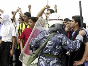 احد عناصر مكافحة الشغب يقف في مواجهة متظاهرين في النامة