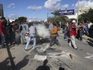 اناس يتجمعون حول سيارة عقب انفجار قنبلة داخلها في بنغازي يوم الخميس