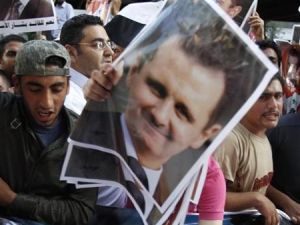 سوريون يعيشون في لبنان يحملون صور الرئيس بشار الاسد في مظاهرة مؤيدة لحكومته في بيروت
