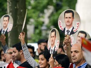  Demonstrators raise portraits of Syrian President Bashar Assad on September 8, 2013 in Brussels to protest against a potential military strike against Syria. (AFP)
