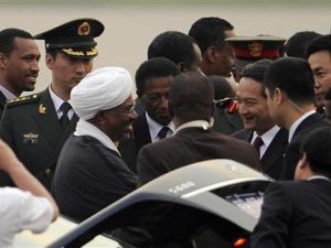 الرئيس السوداني عمر البشير (الثالث من جهة اليسار) يصافح المسؤولين الصينيين لدى وصوله مطار بكين الدولي يوم الثلاثاء.