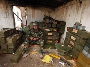 مدني انضم إلى افراد الجيش الذين انقلبوا ضد نظام القذافي داخل مستودع ذخيرة في بنغازي
