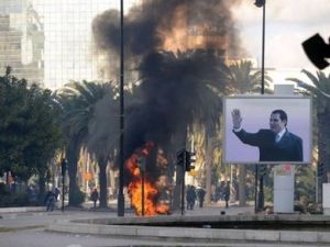 الدخان يتصاعد من نيران اشعلها المتظاهرون قرب صورة لبن علي في العاصمة تونس