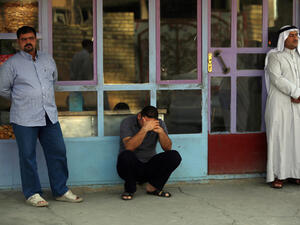 Iraqi men mourn family members on July 14, after an attack the day before (source: AFP / AHMAD AL-RUBAYE)