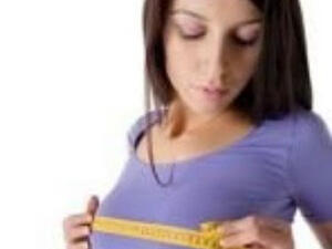 A woman measures herself for a bra.