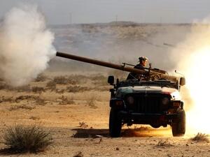 مقاتل من الثوار الليبيين يطلق قذيفة مدفعية باتحاه سرت