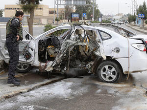 Security officials examine a car after a bomb in Kirkuk Wednesday (Reuters)