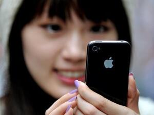 A Chinese woman looks at her iPhone.