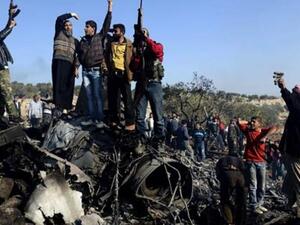 Syrian rebels celebrate the downed jet of Assad's forces.