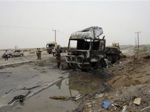 جنود يفحصون حطام السيارة الملغومة في موقع الهجوم 