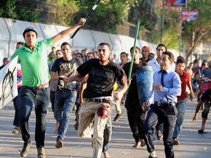 Pro-army supporters chase a bloodied pro-Morsi activist (center) in Cairo on July 22. (AFP / FAYEZ NURELDINE)