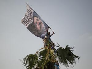 A man waves a flag picturing ousted president Mohamed Morsi on July 9, 2013. (source: GIANLUIGI GUERCIA / AFP)