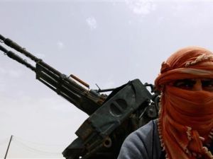 مقاتل من المعارضة الليبية يقف عند البوابة الغربية لمدينة اجدابيا