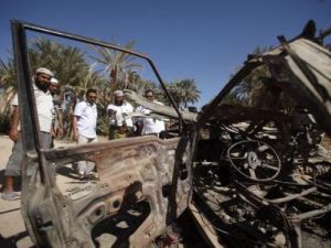 يمنيون بجوار سيارة دمرها هجوم طائرة امريكية بدون طيار في حضرموت

