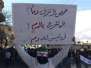 محتج يرفع لافتة خلال مظاهرة ضد الاسد قرب دمشق يوم الجمعة
