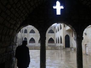 رجل مسيحي يقف امام مدخل دير في مشتاية قرب حمص
