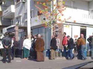 سوريون يصطفون في طوابير طويلة للحصول على اسطوانات غاز طهي في حي بمدينة حمص
