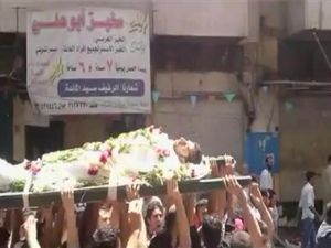 متظاهرون يحملون جثة متظاهر قتل في حمص