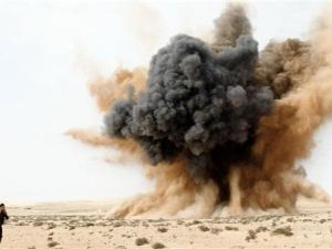 احد الثوار يسد اذنيه اثناء انفجار قنبلة القتها طائرة تابعة للقوات الجوية الليبية الموالية للزعيم معمر القذافي في الصحراء قرب البريقة