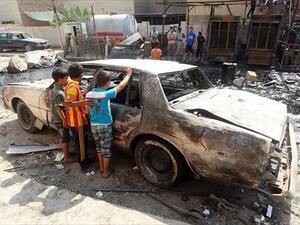 Iraqi children inspect a burnt-out car at the site of a car bomb attack that exploded the previous day in a commercial street of Baghdad's eastern neighbourhood of Mashtal on Monday. On Tuesday, a fresh wave of violence across the country killed at least 24 people. (AFP)