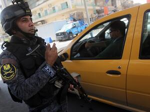 An Iraqi policeman checks vehicles on July 23 after security measurers were increased in Baghdad. (AFP / AHMAD AL-RUBAYE)
