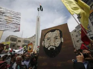 فلسطينيون يرفعون صورة مرسومة بالخبز للسجين سامر العيساوي أثناء احتجاج في رام الله بالضفة الغربية