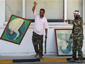 مقاتل من المعارضة يلقي صورة للقذافي على الارض عقب السيطرة على مصفاة نفط الزاوية غربي طرابلس
