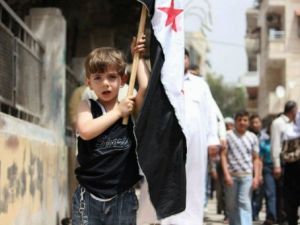 طفل يحمل علم الثورة السورية في كفرتخاريم خلال تظاهرة ضد النظام 
