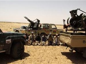 مقاتلون من المعارضة الليبية يصلون بين سياراتهم على الجبهة في بلدة بير غنام 
