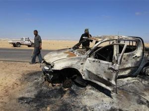 مسلحون من المعارضة يتفقدون آثار غارات حلف الاطلسي على اجدابيا يوم الاثنين
